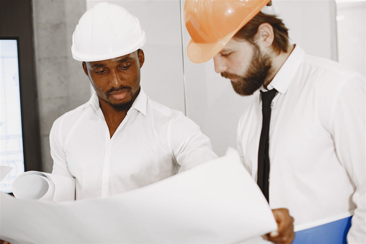 Dos contratistas revisando planos de construcción