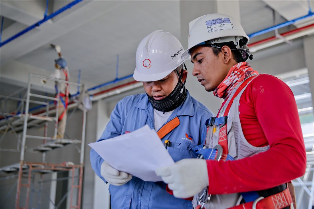 Cuadrilla revisando planos dentro de una obra en construcción