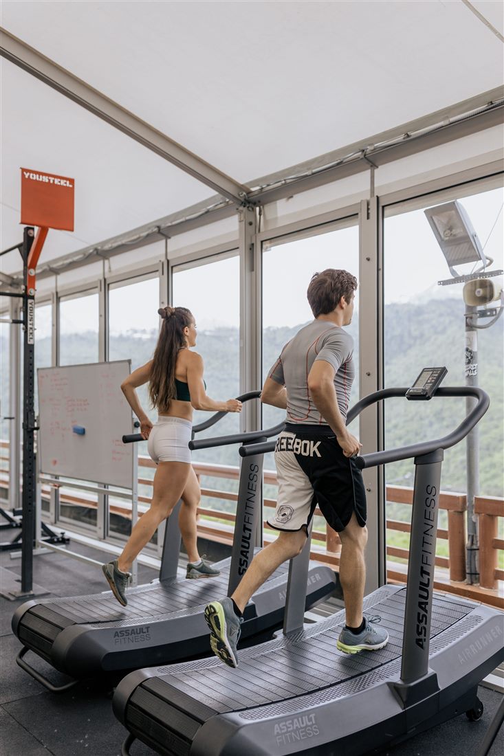 Área de cardio junto a ventanales del gimnasio