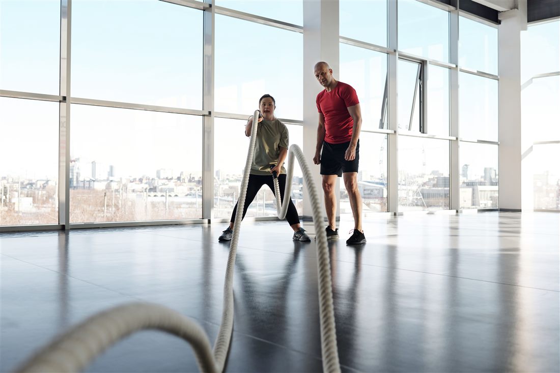 Entrenamiento funcional con cuerdas en zona de gimnasio luminosa