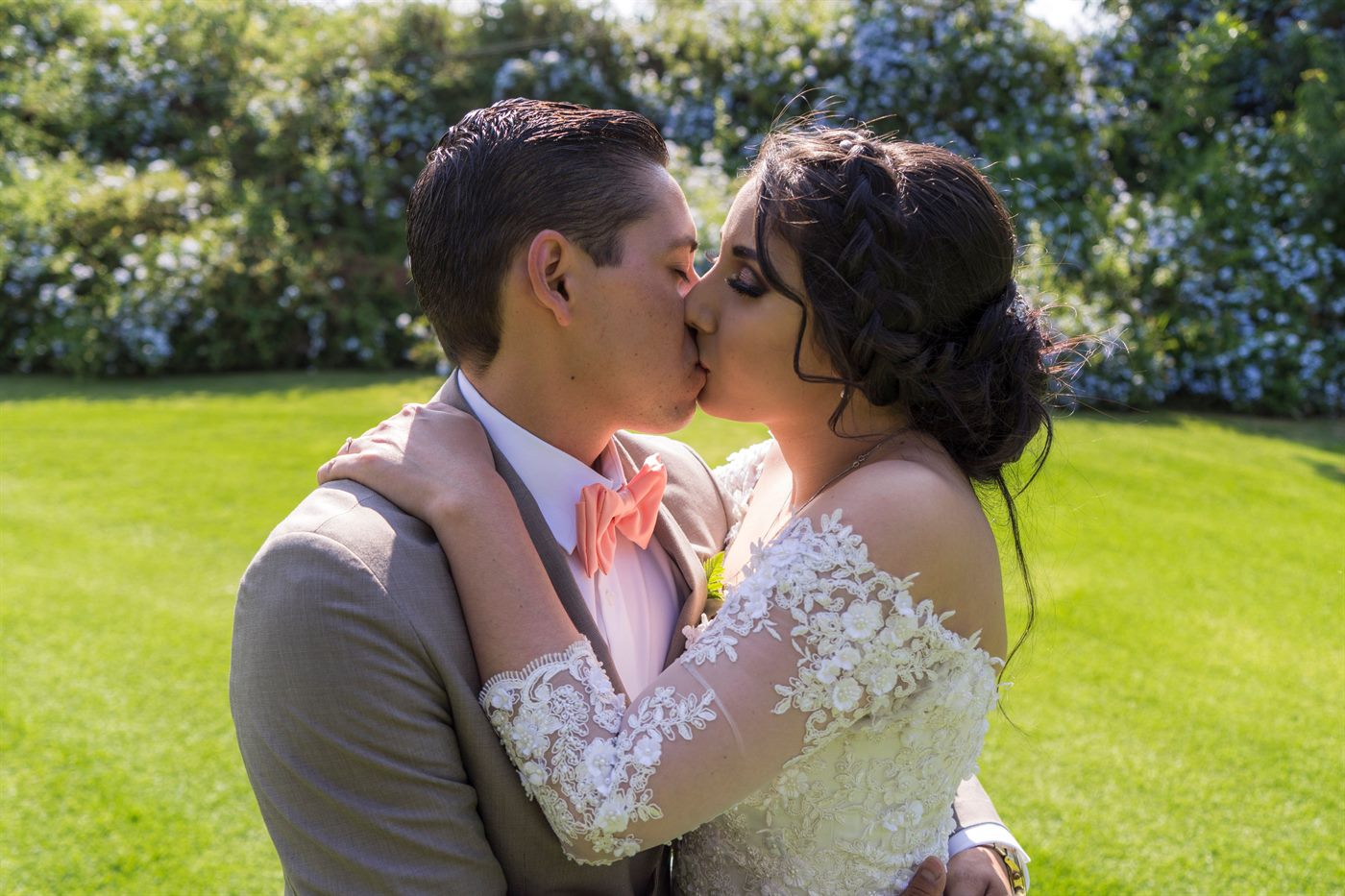 Novios besándose sobre el césped