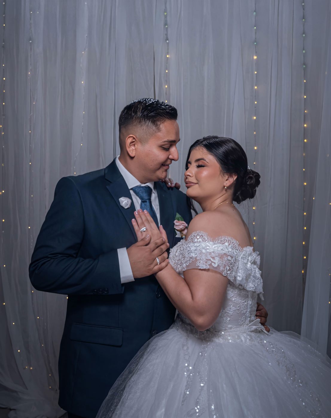 Pareja de novios abrazada durante la fiesta con luces cálidas